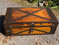 Front and top angled view of the antique pine steamer trunk showing flat top, metal cross straps, lock, and side rope handle.