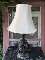 Full view of the table lamp showing white fabric shade and detailed elephant base.