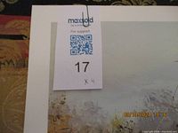 Set of four prints stacked, showing white matting and partial view of print surface with signs of wear on mat edges.