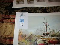 Photo showing part of one dry dock print with Collin’s signature and matting. Auction lot label '10' placed on the matting.