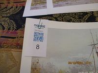 Photo showing 5 prints with white matting and part of artwork with a MaxSold support tag and lot number 8