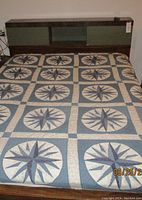 Double bed frame with quilt showing the bed and headboard with shelves and sliding doors.