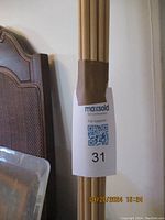 Photo of a bundle of wooden dowels tied together, showing cylindrical rods of medium thickness and varying lengths.