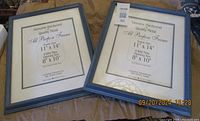 Two light blue hardwood photo frames lying side by side showing the size and mat information for 11" x 14" frame with 8" x 10" opening.