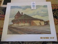 Full view of the print showing the CN station building with railway tracks in front and cloudy sky above.