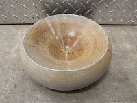 Top-down view of the bowl showing smooth interior with speckled glaze, beige turning brown towards the center.