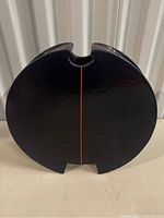 Front view of a large black ceramic art piece with a red line center