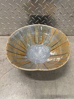 Front view showing interior of large ceramic bowl with blue-gray and brown speckled glaze and radiating line pattern