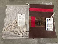 Photo showing the handwoven textile or table napery with fringed edges and attached Laura Fry Weaving Studio tag detailing custom hand weaving in Prince George, BC, Canada.