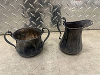 Both silver pieces together: creamer and sugar bowl, showing size and tarnished condition.