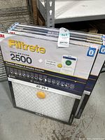 Five 3M Filtrete Smart Air Filters 2500, packaged, stacked upright showing front packaging with product specs and app compatibility.