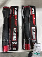Front view of two sealed EverBright LED flashlights in blister packaging, showing black and red flashlights with branding and specifications.