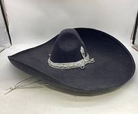 Full view of the black mariachi sombrero showing silver decorative band and chin cord