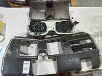 Dashboard parts laid out including plastic housing with attached gauge cluster.