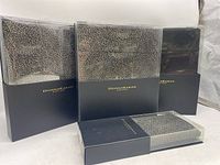 Four Donna Karan New York boxed bedding items including bed skirt, flat sheet, fitted sheet, and pillow cases.