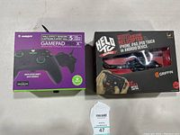 Two boxed gaming items, Griffin HELI Assault missile launching helicopter and Gamepad Pro X controller.