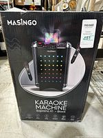 Front view of boxed karaoke machine with product image and branding.