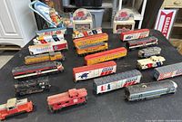 Wide angle view showing assortment of vintage train cars including locomotives and boxcars.