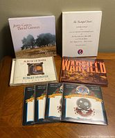 Photo showing all CD sets and four temporary tattoos on a table.