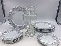Overall lot photo showing Waterford crystal vase with a set of Imperial China Whitney plates arranged around it.