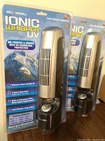 Pair of Bell+Howell Ionic Whisper UV air purifiers still in sealed packaging showing front with product details.