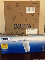 Photo of Brita Water Filtration System box and box of six replacement cartridge filters, packaging shows brand and product info