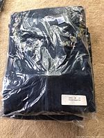 Photo of six packed denim jumper sets in clear plastic packaging, visible folded blue denim fabric.