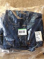 Four pairs of L.L. Bean women's denim pants, size 16 regular, folded and sealed inside clear plastic packaging showing label details.