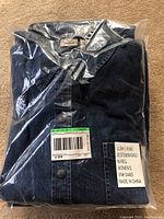 Packaged dark blue women's denim shirt by L.L. Bean, size 16 regular, with visible label and barcode.