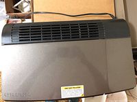 Top-down view of Oreck air purifier showing bronze metal casing and black ventilation grille.