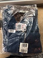 Single jacket sealed in clear plastic with retail tags showing brand and size 2X.