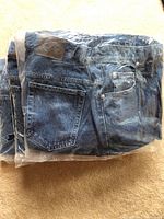 Five pairs of folded St. John's Bay denim pants in plastic packaging, showing overall lot quantity and packaging condition.