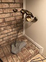 Wind chimes shown from front angle, displaying multiple disc chimes on rods anchored in stone base.