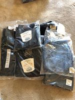 Photo showing seven pairs of women's denim pants still sealed in original packaging, including visible L.L. Bean and St. Johns Bay labels and size tags.