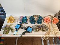 7 floral headpieces displayed on a table showing diverse colors and styles with headbands and clips