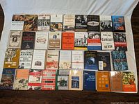 Overview of the entire lot showing 40 history books arranged in rows on the floor.