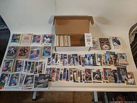 Large assortment of Toronto Blue Jays baseball cards laid out on a table including many cards still inside a box.