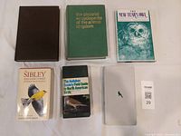 Top-down view of six bird and animal books showing front covers including one with an owl illustration and a brown leather-bound book.