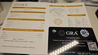 Clear photo of GRA grading report for 1 carat pear cut moissanite showing VVS1 clarity, D color, excellent polish, symmetry, and certificate details.