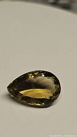 Pear-shaped natural champagne colored citrine gemstone, faceted cut, 14.57 carats, VS clarity, shown on plain light background.