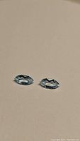 Pair of marquis cut natural sky blue topaz gemstones, well faceted, clear, shown on neutral background.