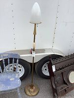 Full view of the vintage metal floor lamp with white opaque shade attached. Shows flaking paint on the round metal base and overall wear.