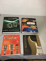 Photo showing all four guitar books arranged flat on a surface, titles visible.