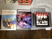 Top-down photo showing a collection of music CDs and DVDs including Supertramp, Meat Loaf live DVD, and U2 albums with cover art visible