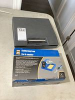 Gray plastic case with handle containing Weller soldering tool closed, placed on table.