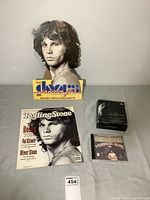 Photo showing all items in lot: magazine, CD jewel case, CD box, and freestanding display.