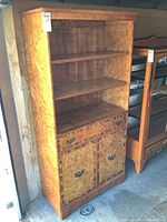 Front view of the vintage wood bookcase cabinet highlighting the shelves, drawer, and cabinet doors.