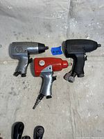 Three 3 1/2 inch air impact wrenches together on fabric background, showing different colors and shapes.