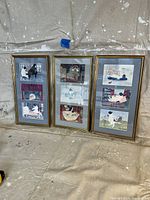 Three vintage framed artworks with multiple dog-themed prints in gold-tone frames, standing against a wall.