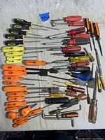 Full collection of assorted screwdrivers laid out showing various handle colors, sizes, and types.